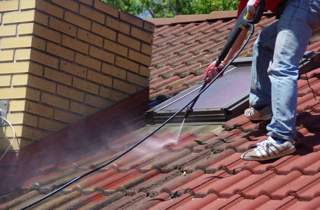 A technician from Upstate Softwash washing a roof in Saratoga Springs, NY, improving energy efficiency and curb appeal.